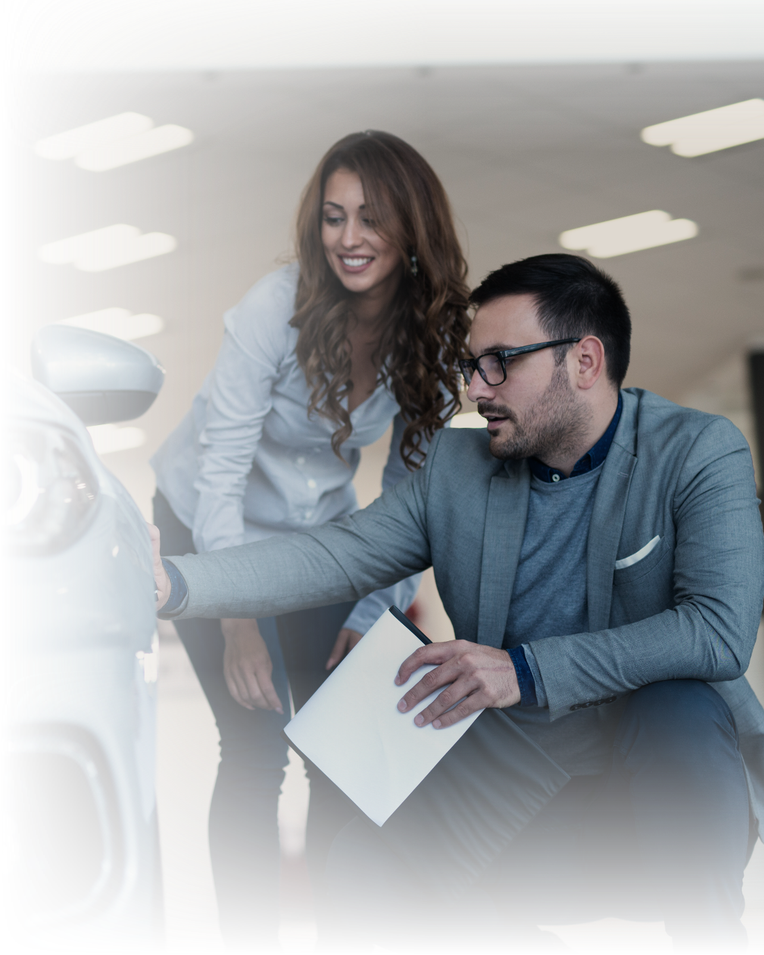 Un asesor de concesionario mostrando una unidad a una compradora en el showroom